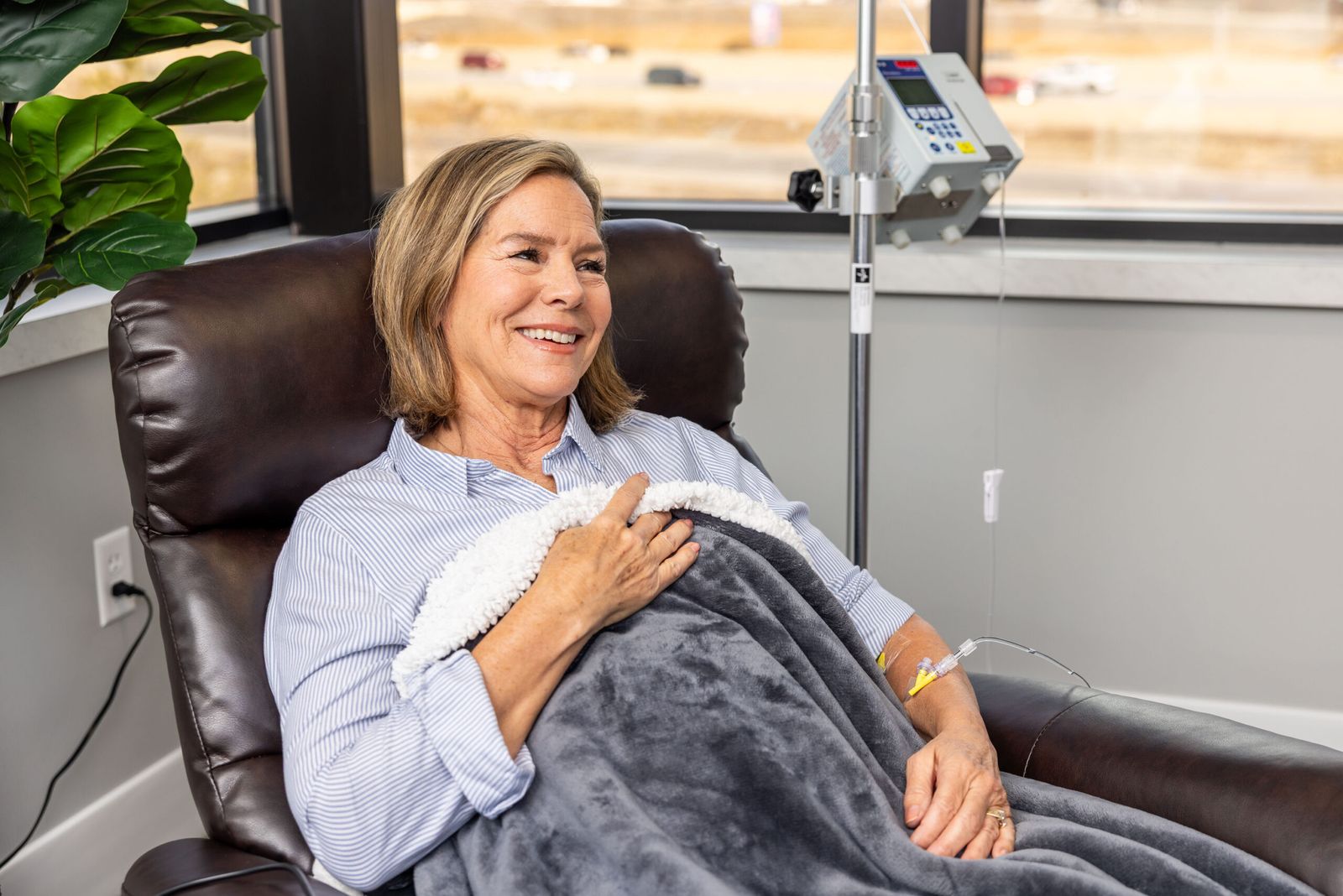 A patient resting under a blanket during an infusion at Pure Infusion