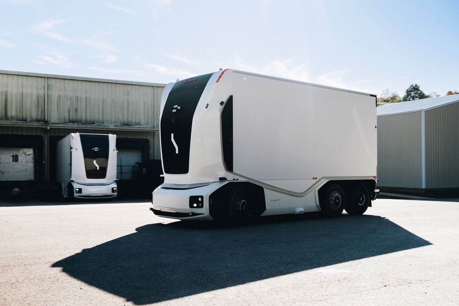 Two Einride autonomous trucks at a loading dock