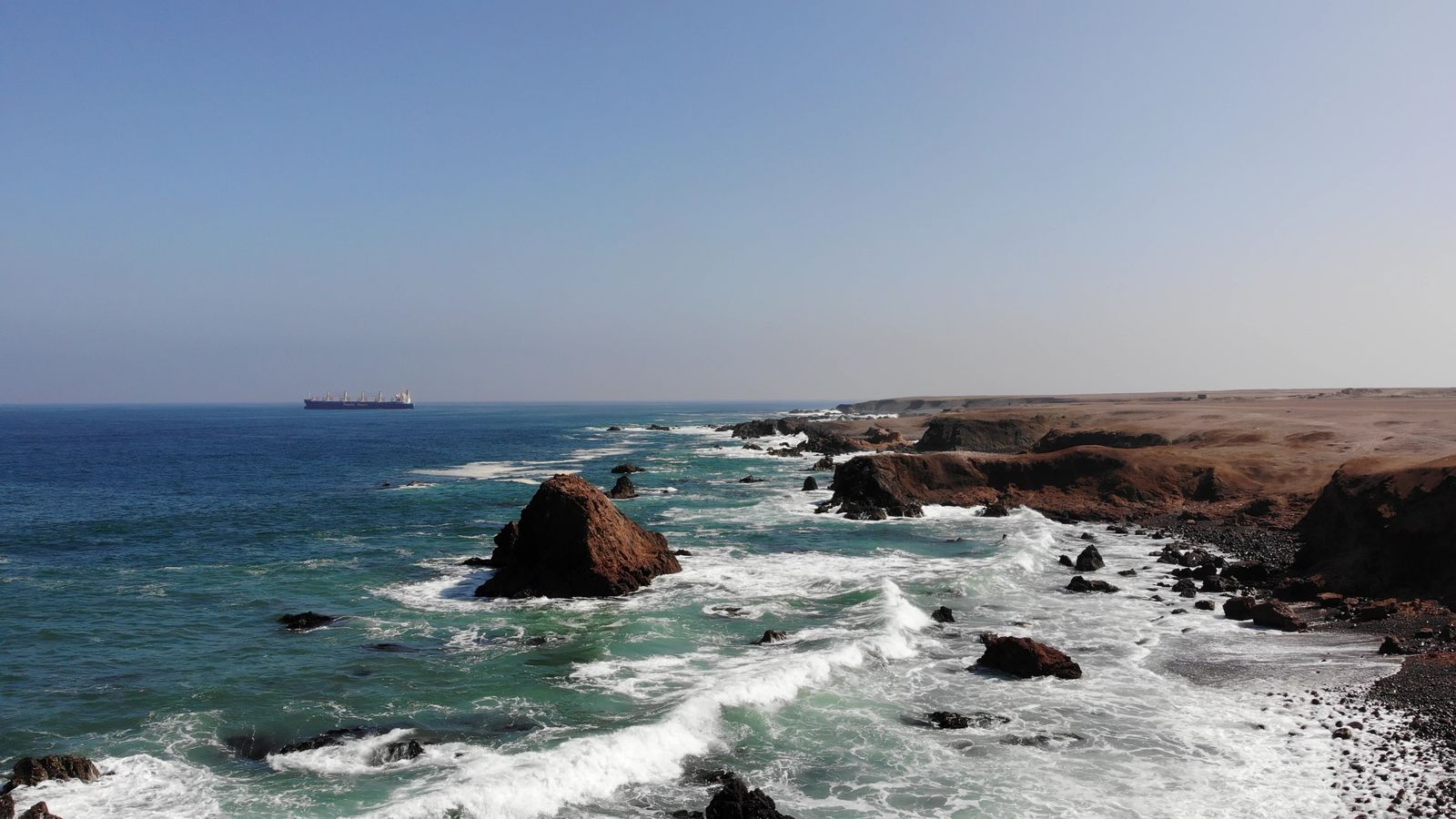 Surf and a sea stack on the coast of northern Chile at BUILD's desalination project site